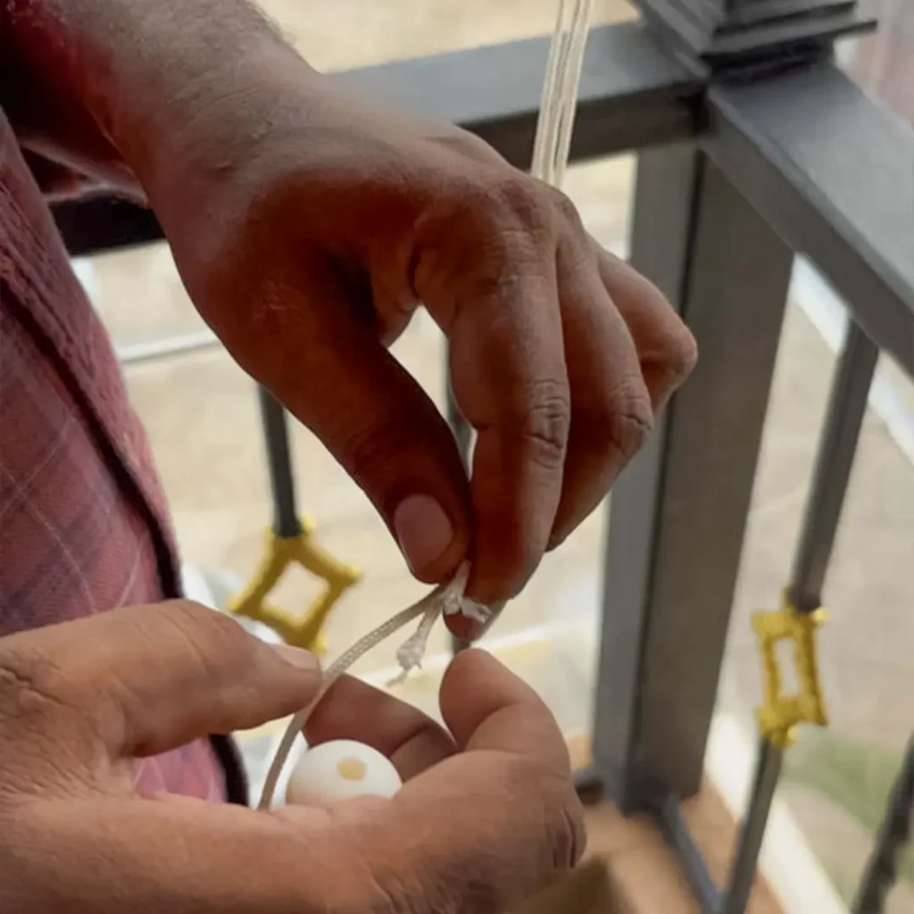 Salman Azam aligning thread during monsoon blinds installation at Candolim terrace for S.N Interiors Goa