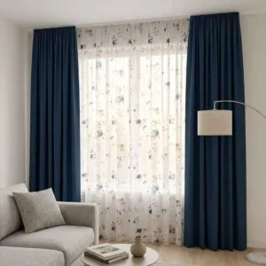Premium navy blackout curtains with floral sheer drapes installed by SN Interiors Goa in a modern living room.