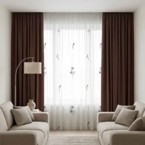 Premium chocolate-colored blackout curtains and floral sheers installed by SN Interiors Goa in a contemporary lounge.