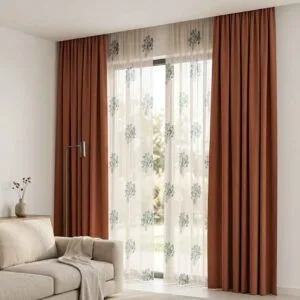 Premium burnt orange blackout curtains and botanical patterned sheers installed by SN Interiors Goa.